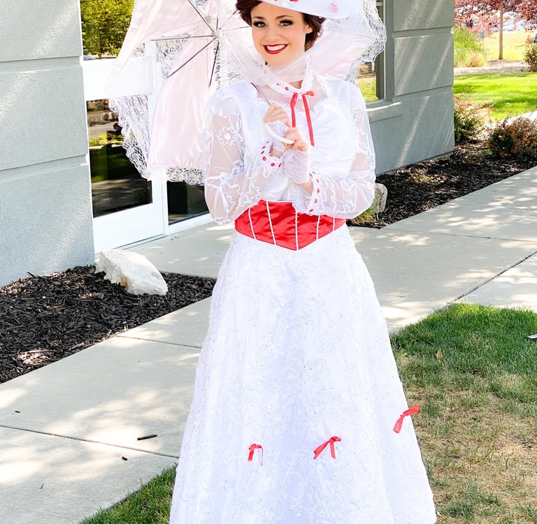 Beautiful performer in a jolly holiday white lace dress holding a parasol.