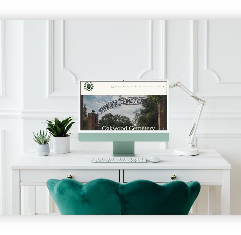 Oakwood Cemetery website displayed on a desktop computer in a modern home office setting.