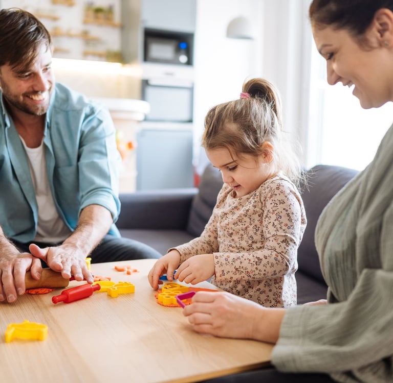 Parents participating in a child-centered speech therapy session with their school aged child.