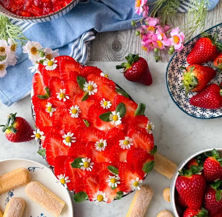 Tiramisù di Pasqua decorato con fragole e fiori edibili visto dall’alto