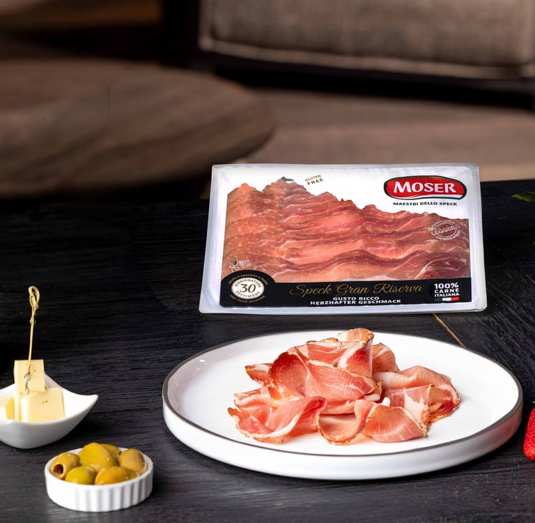 Speck Gran Riserva Moser servito in degustazione con formaggio, olive e fragole