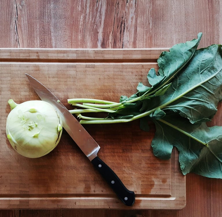 Cime di rapa fresche su tagliere di legno con coltello