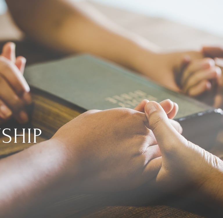 friends holding hands at a table with the Bible in the center with the word fellowship