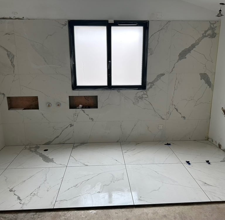 Résultat final après rénovation complète avec pose de carrelage marbre blanc grand format. Harenova