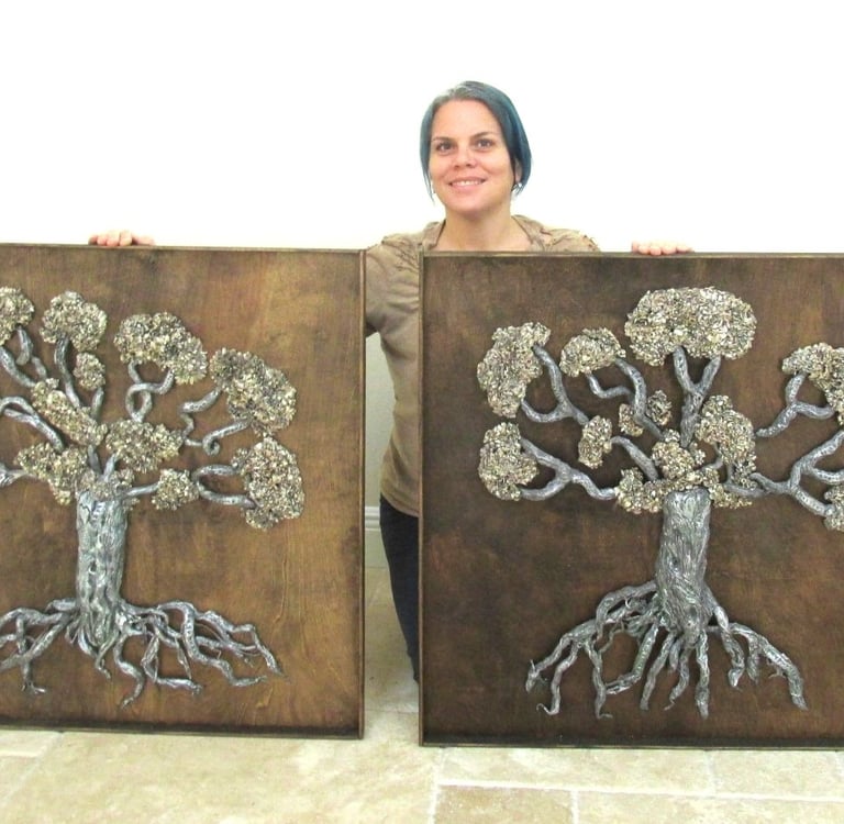 visual artist holding sculpture of trees