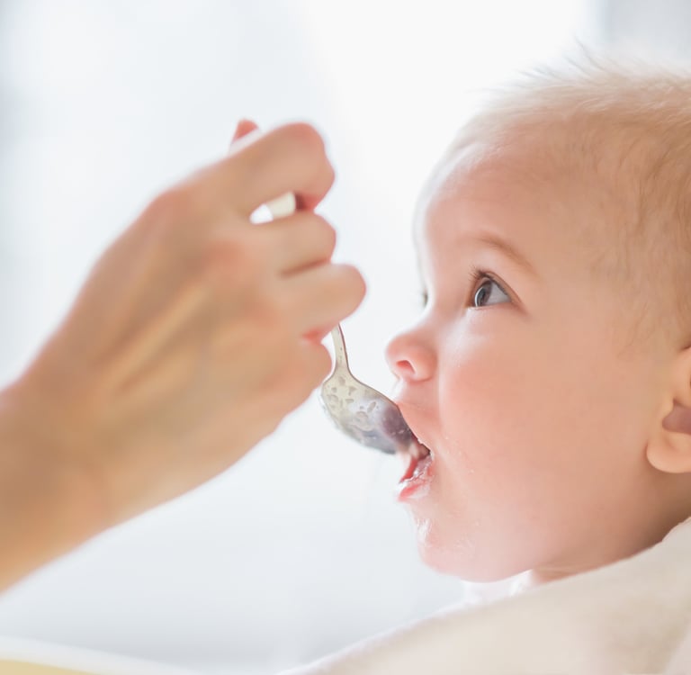 a baby gets food from a spoon