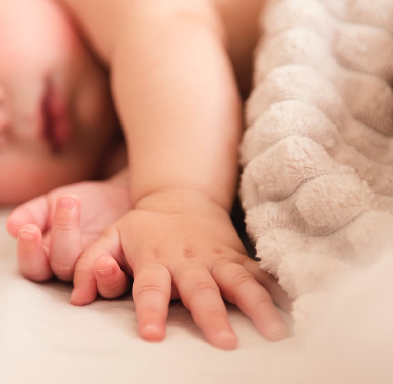a baby is laying on a bed with a blanket