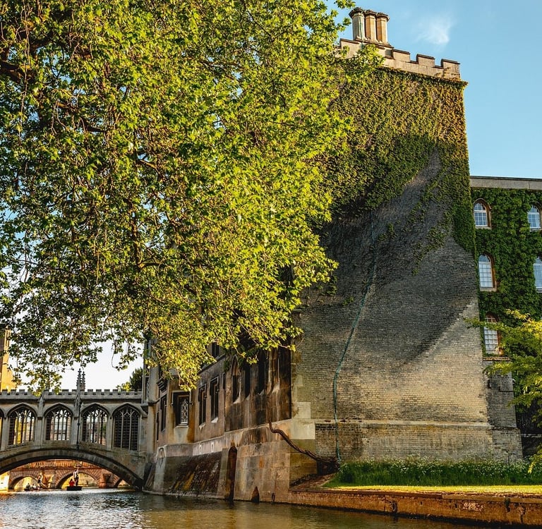 The Bridge of Sighs at St John's College, Cambridge, beside the River Cam with ivy-covered stone walls.