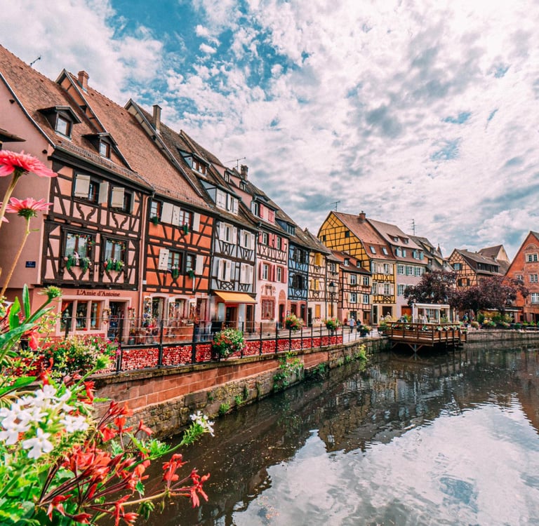 Colorful half-timbered houses along the Lauch River canal in Colmar, France's Little Venice district.
