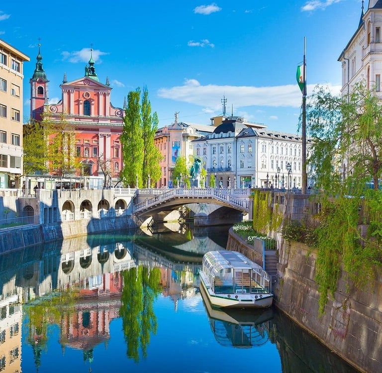 Ljubljanica River in Ljubljana, Slovenia, featuring the Triple Bridge and the pink Franciscan Church.