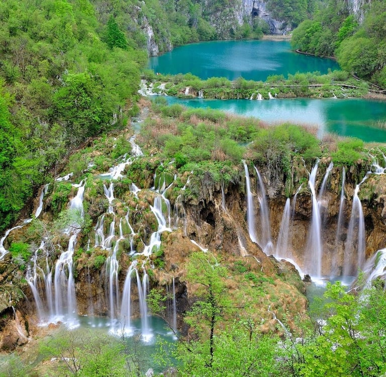 Aerial view of cascading waterfalls and turquoise lakes at Plitvice Lakes National Park in Croatia.