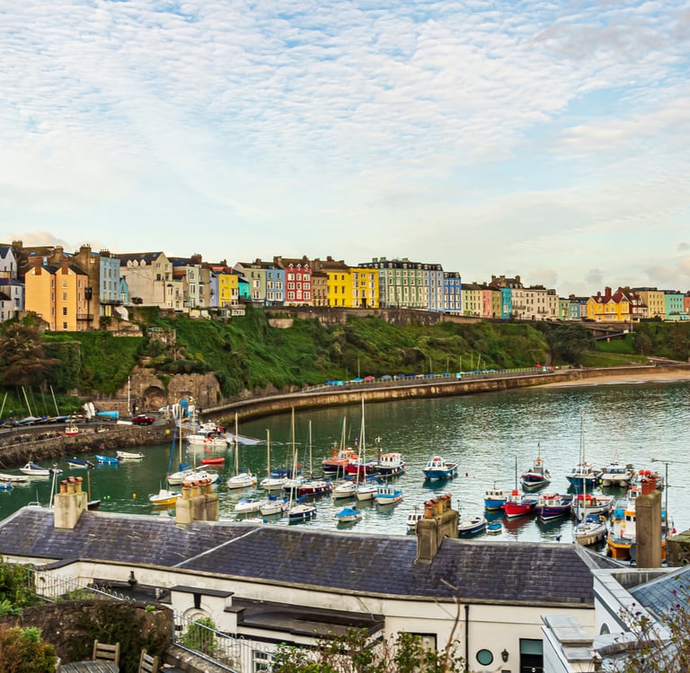 Panoramic view of colorful coastal houses and boats in Tenby Harbour, Pembrokeshire, Wales.