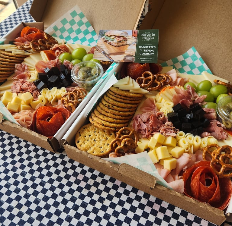 Gourmet charcuterie grazing boxes with artisan meats, cheeses, crackers, and grapes for catering.