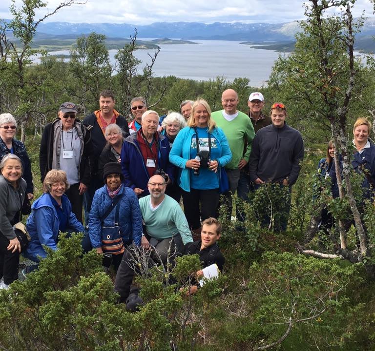 a group of Telelaget members at the top of a hill in norway overlooking a lake