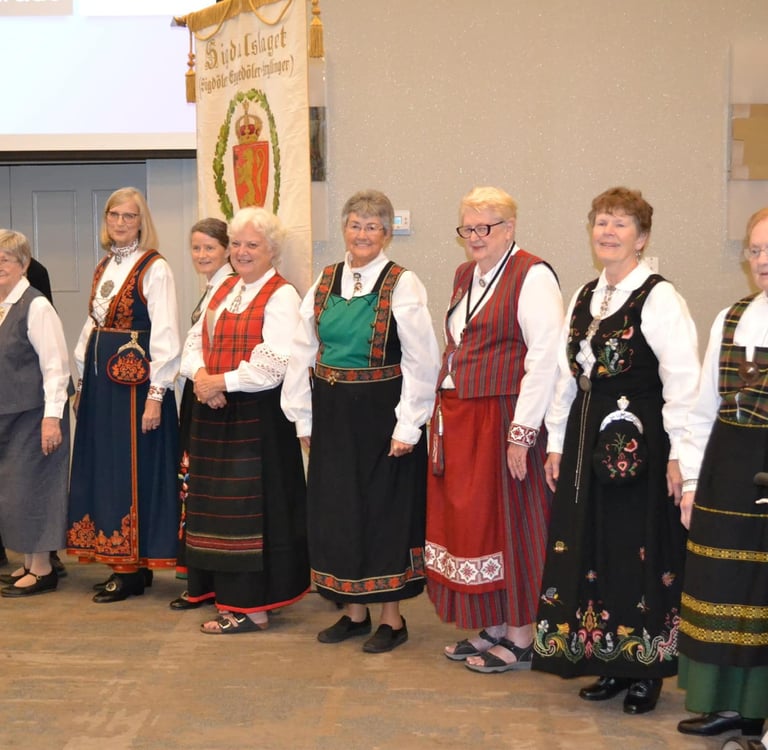 one man and eight women in bunad