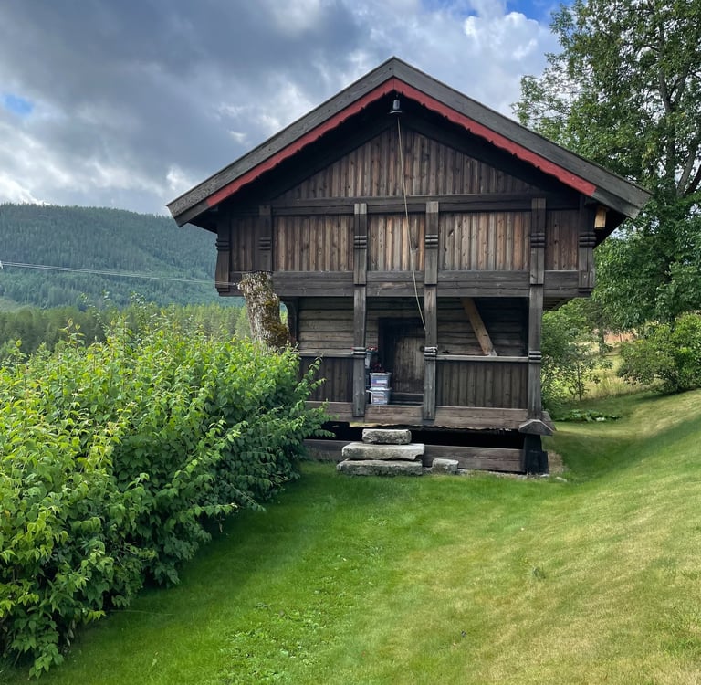 A wooden building, stabbur, with hills in the background-Telelaget