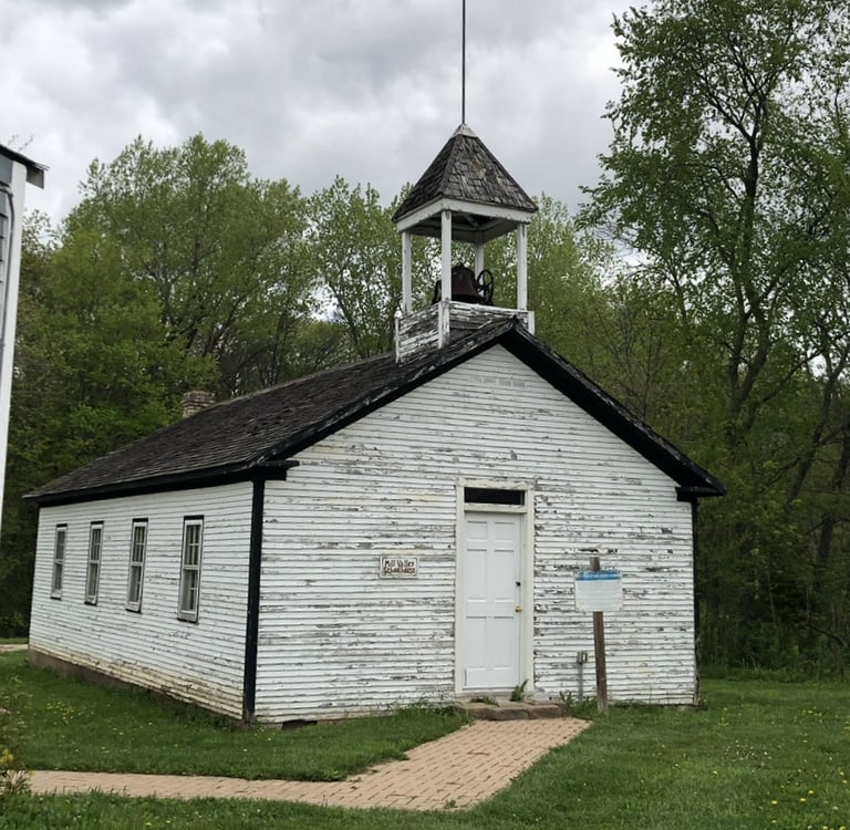 A white wooden church with a bell