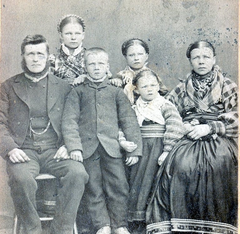 A bearded man, his wife, three daughters and one son in traditional dress circa 1890s