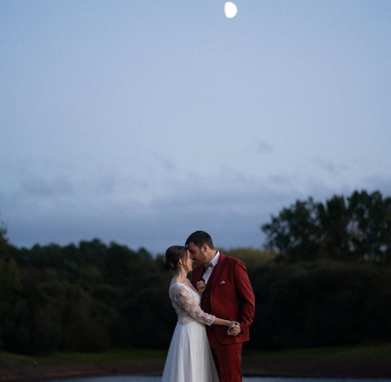 un couple face à face près de l'eau la nuit lors de leurs photos de mariage à Guignen, à Rennes