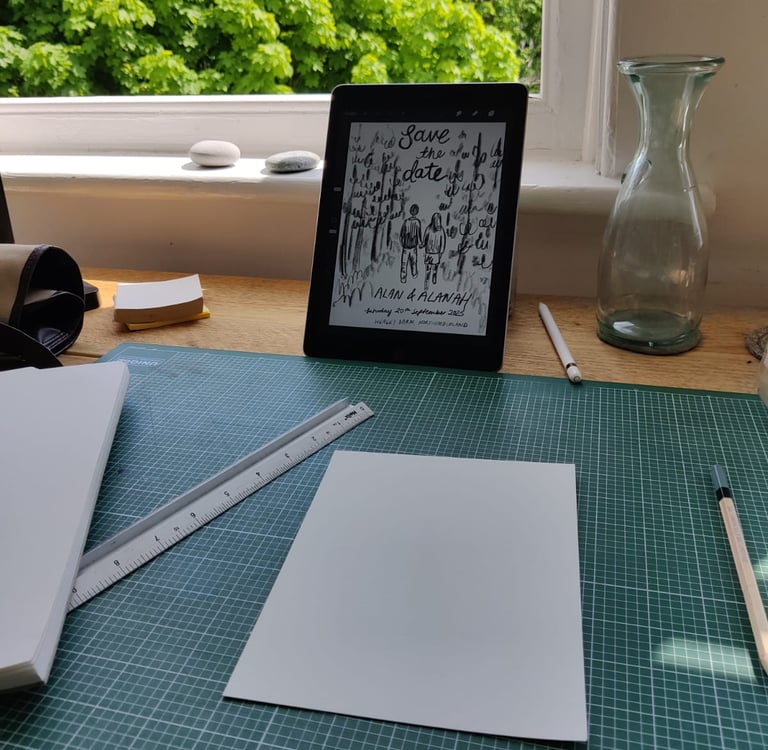Eleanor's (elsillustrations) hand holding a pen and a tablet with a  sketch of the save the dates