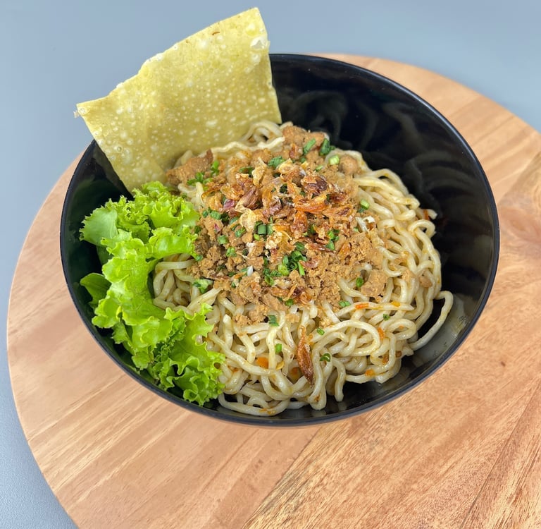 Mangkuk mie ayam dengan topping ayam, daun bawang, dan kerupuk pangsit di Depot Mie Ayam RATU