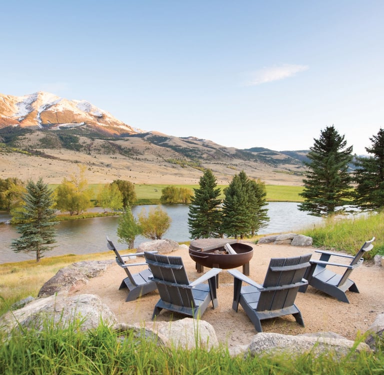 fire pit and chairs overlooking a lake