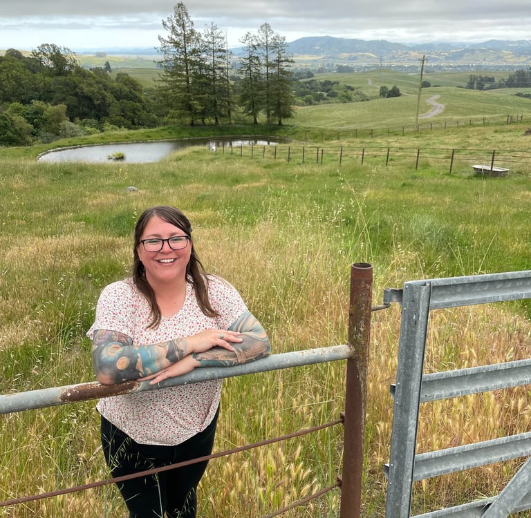 a woman standing in front of a fenced in area