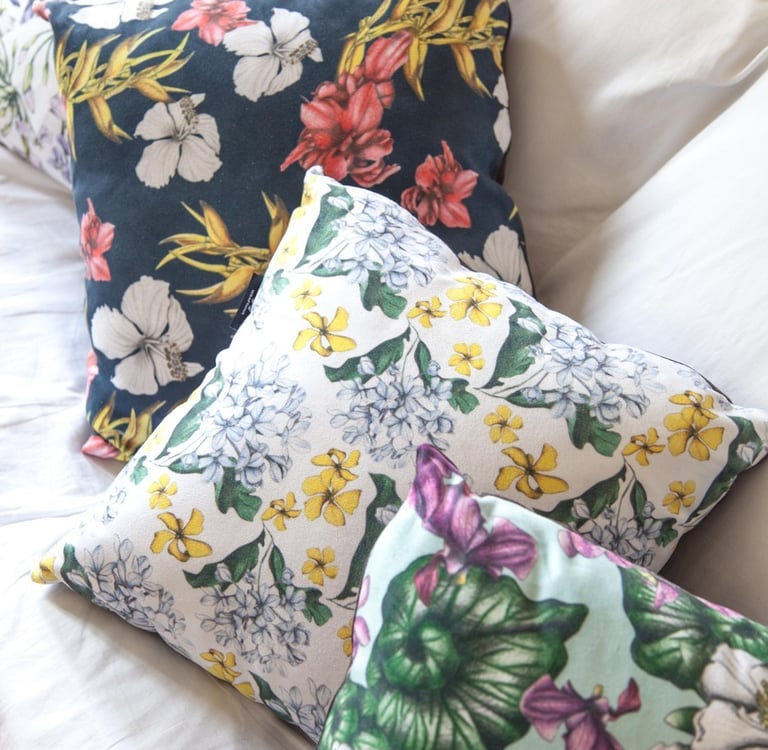 Four Pillows with multicolor hand-drawn floral patterns on a white couch