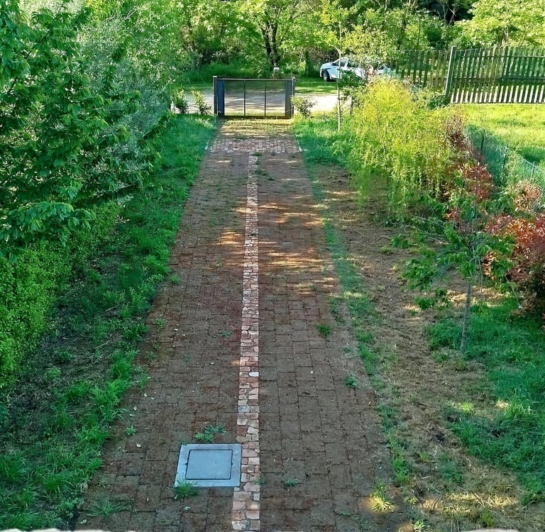Giardino privato in vendita con vialetto pavimentato e accesso carrabile.