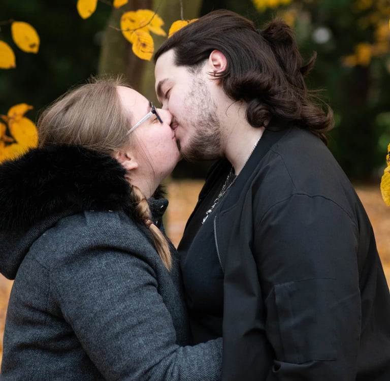 Deux amoureux s'embrassant sous les feuilles jaunes de l'automne