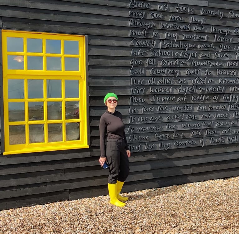 photo of Micha wearing bright yellow welly boots next to yellow window