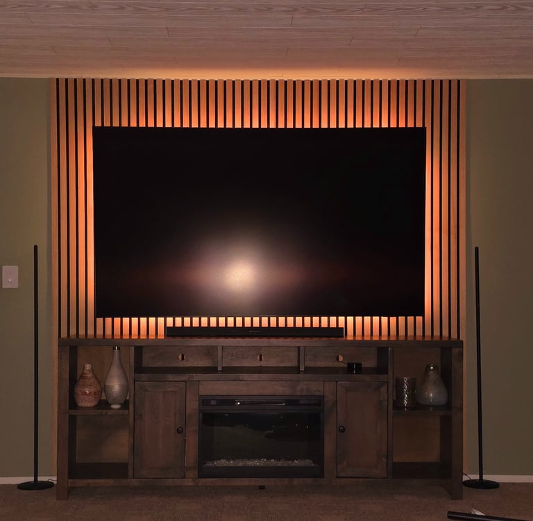 Modern home theater setup featuring a wall-mounted TV on a wood slat accent wall with LED backlight.