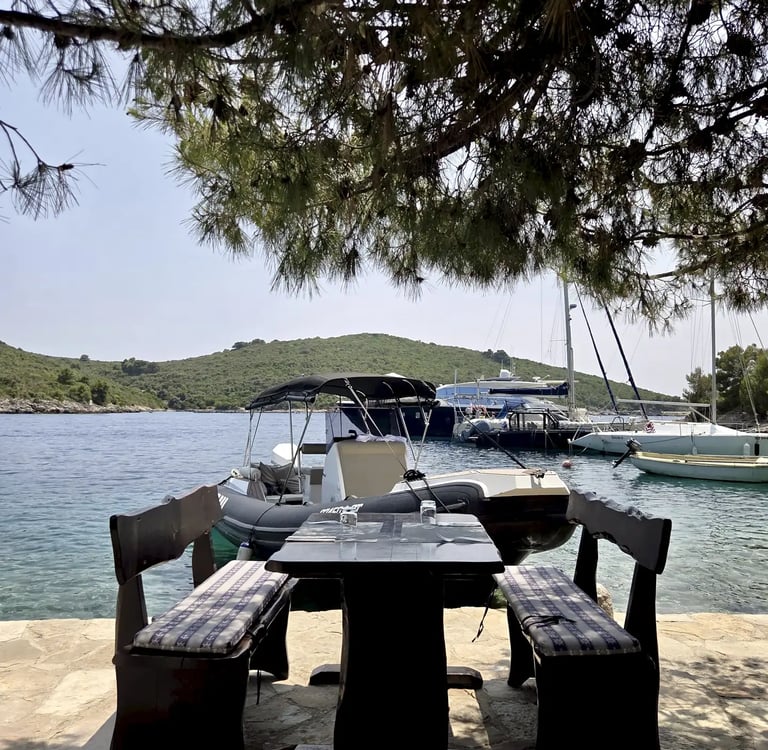 Outdoor dining table at Restaurant Sesula on Solta and speedboat in the background during a private boat tour from Split