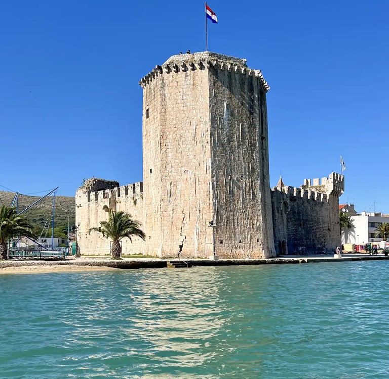 Sea level view of Kamerlengo Fortress and UNESCO protected city of Trogir during a private boat tour from Split, Croatia