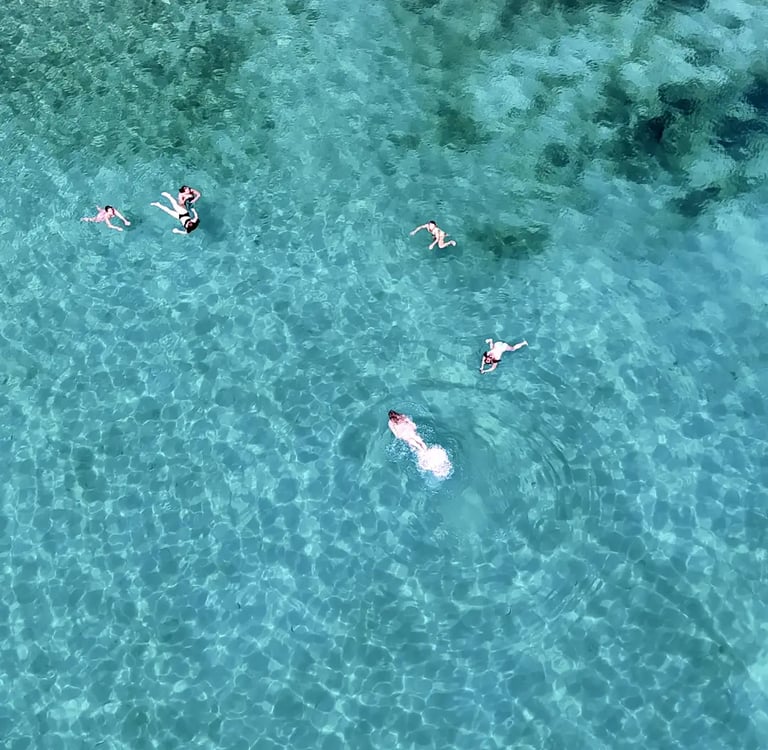 Aerial view of girls swimming and snorkeling in a bay near Milna on Brac during a private boat tour from Split, Croatia
