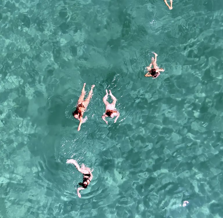 Aerial view of girls swimming and snorkeling in a bay near Milna on Brac during a private boat tour from Split, Croatia