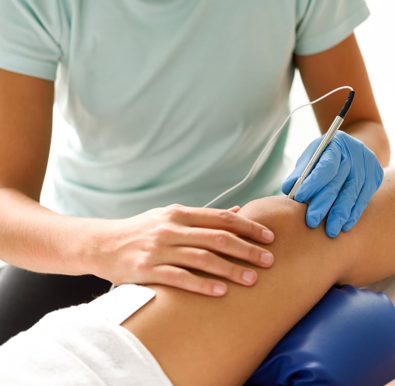 Un médico evalúa qué terapia aplicar en la rodilla de un paciente.