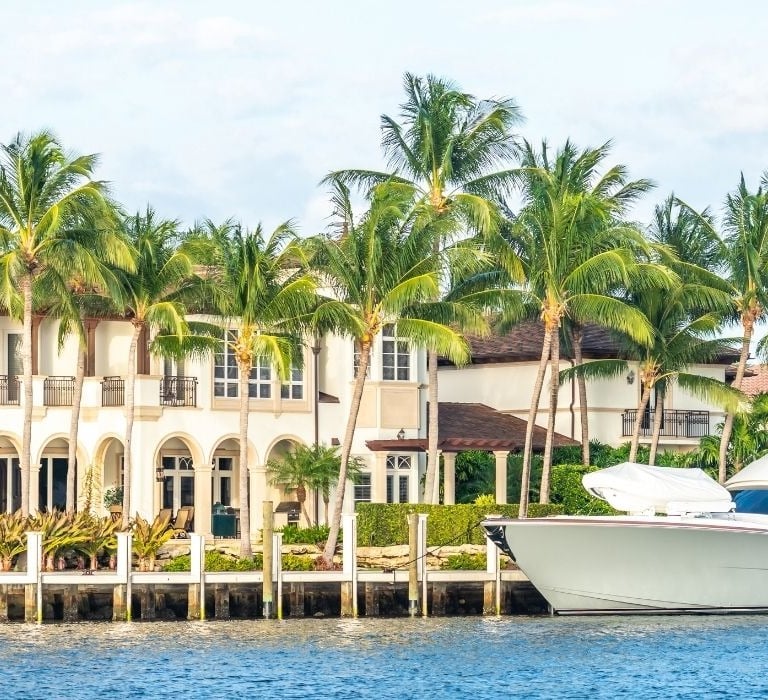large yacht next to large home in florida
