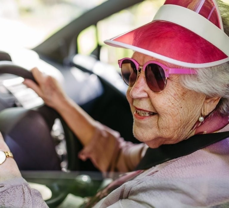 old lady with sun visor driving car