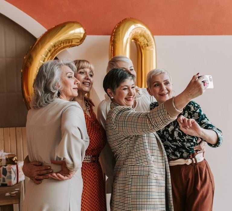 senior women celebrating friend's 60th birthday