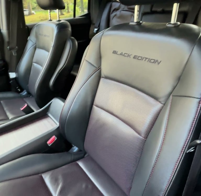 interior mobile detailing of leather seats inside a special black edition truck