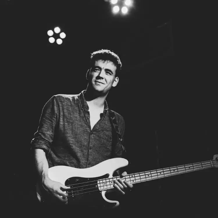 Mosaic's bass player performing a soulful blues-rock groove on stage