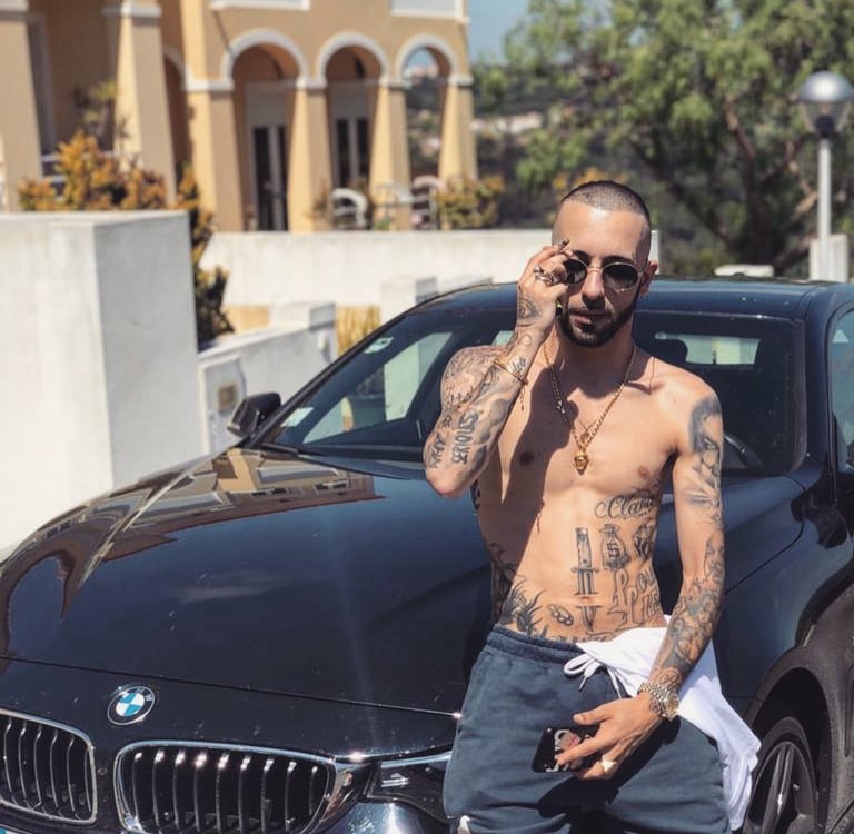 rapper piruka sentado em uma bmw