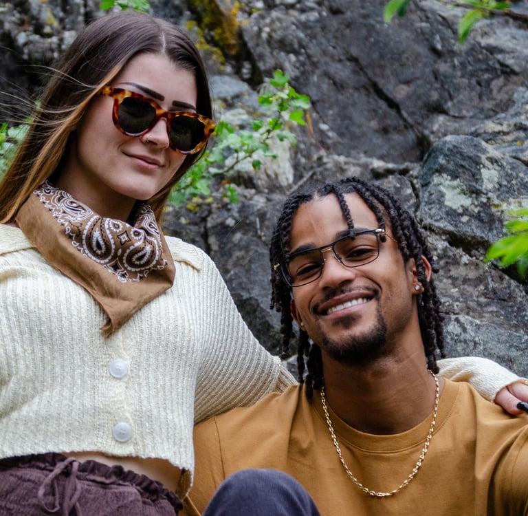 Young Man and woman standing outside, smiling, and wearing fashion eyewear