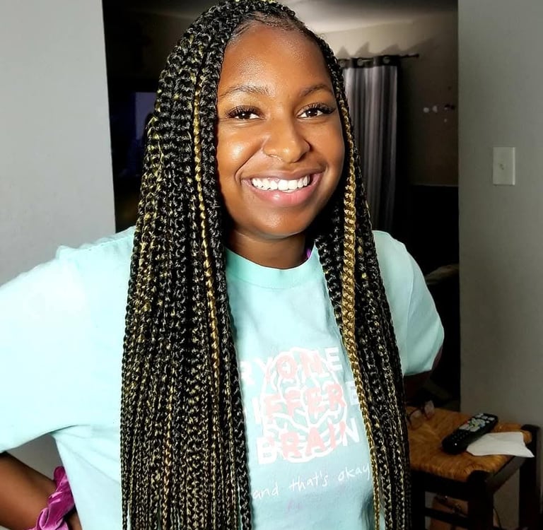 a woman with black and gold box braids