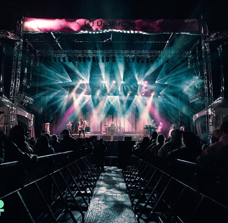 Live band performing on a large outdoor stage with dramatic lighting at VictoFest music festival.