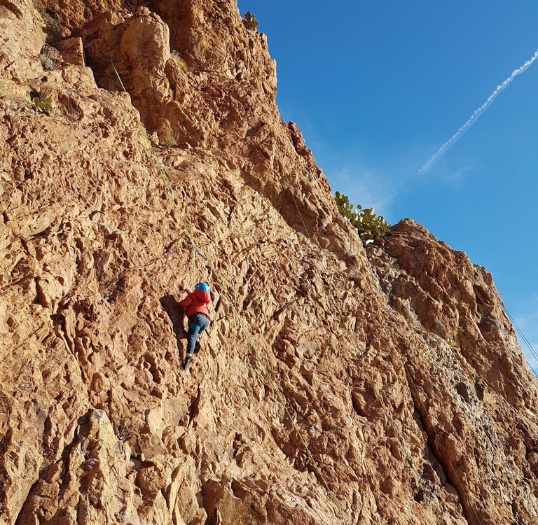 Enfant qui grimpe un mur rougeoyant