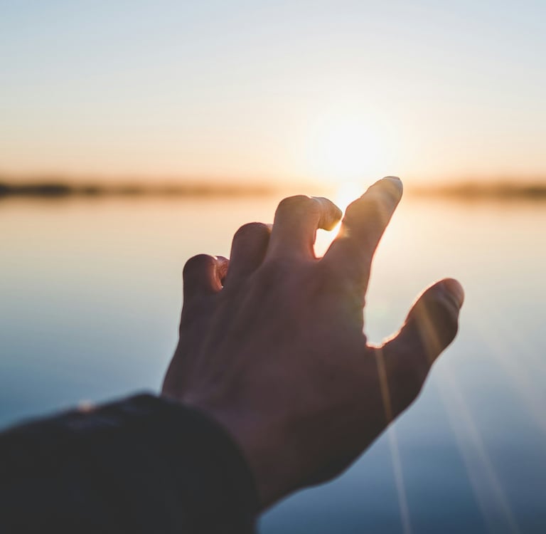 Hand reaching toward sunrise symbolizing hope and new beginnings after probate