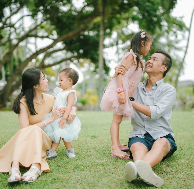 Intimate family moment at The Laguna Nusa Dua Bali, natural luxury family photography in a tropical garden setting.