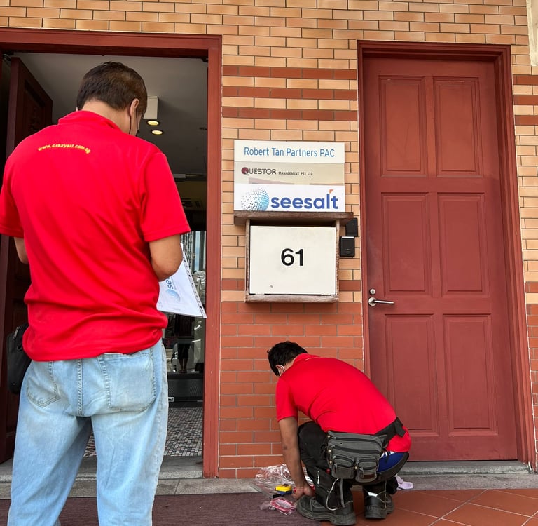 Couple of workers installing SeeSalt logo alongside Questor Management